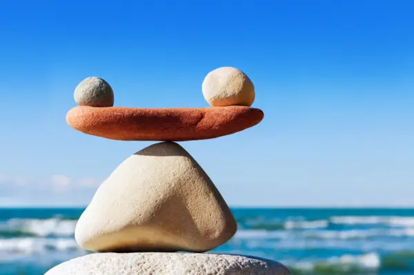 A rudimentary scale made with rocks and a piece of wood to embody the importance of work-life balance for educational leaders