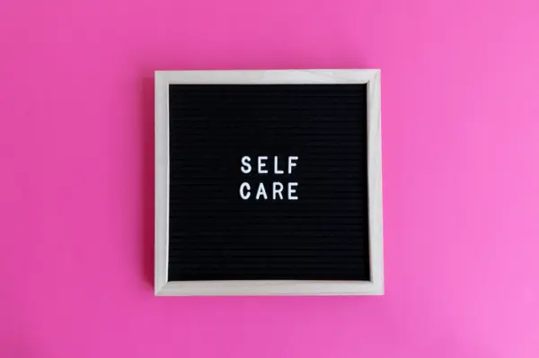 a felt message board that says the words "Self-Care"